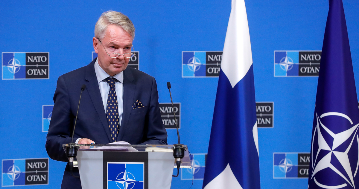 El ministro de exteriores finlandés junto a una bandera de su país y otra de la OTAN.
