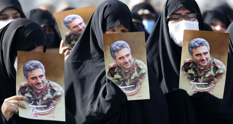 Iraníes enarbolan fotos del coronel iraní asesinado Sayyad Khodai durante su funeral en Teherán.