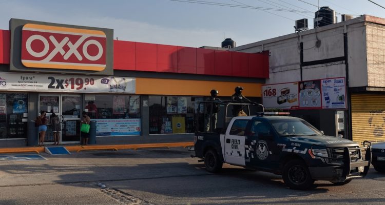 Miembros de la fuerza civil vigilan la zona donde fueron asesinadas Yesenia Mollinedo Falconi y Sheila Johana García en una tienda.