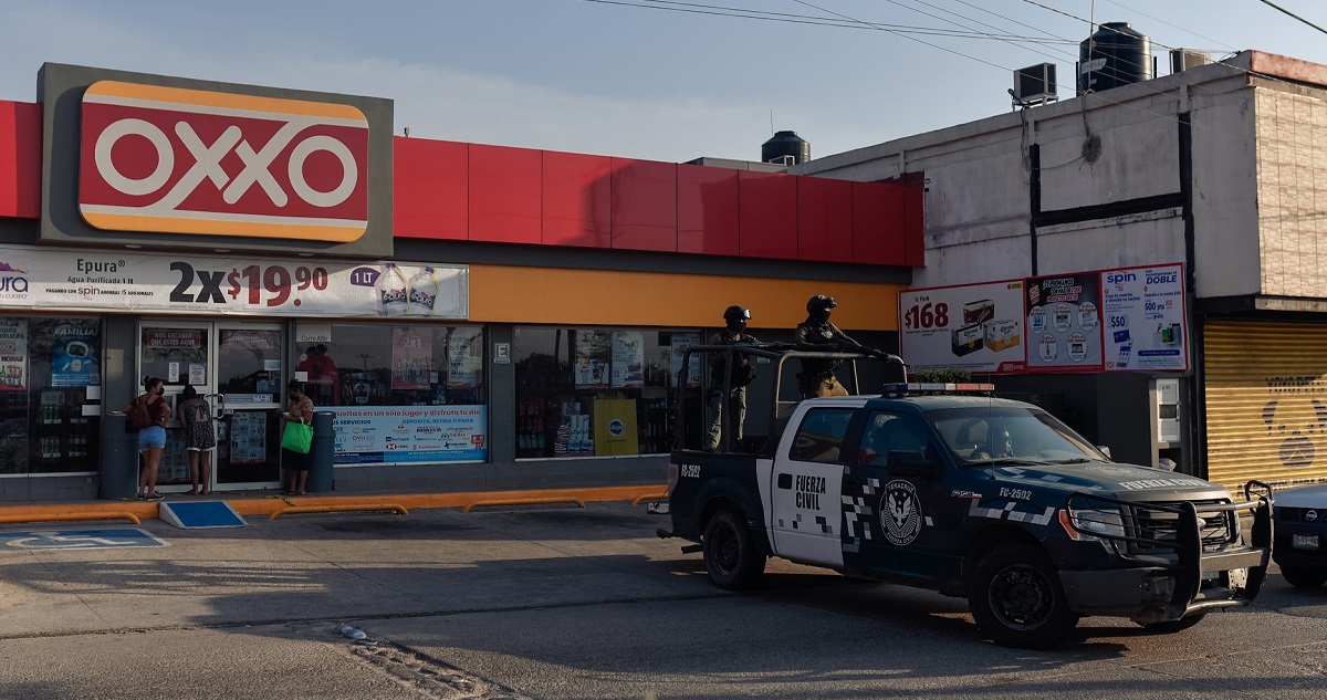 Miembros de la fuerza civil vigilan la zona donde fueron asesinadas Yesenia Mollinedo Falconi y Sheila Johana García en una tienda.