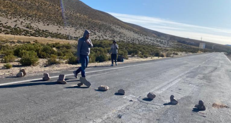migrantes bloquean ruta con piedras