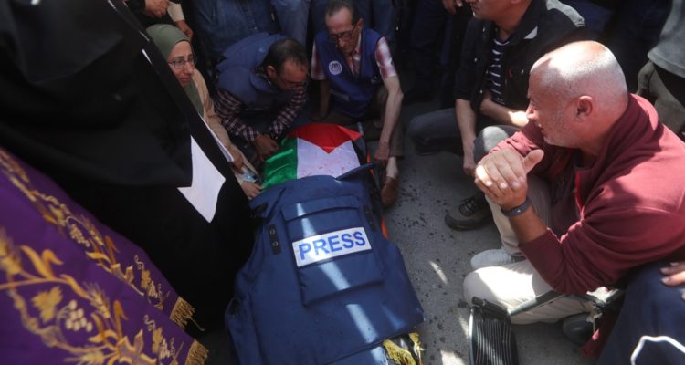 El féretro de la periodista, cubierto por su chaleco de prensa, siendo velado por su familia y amigos.