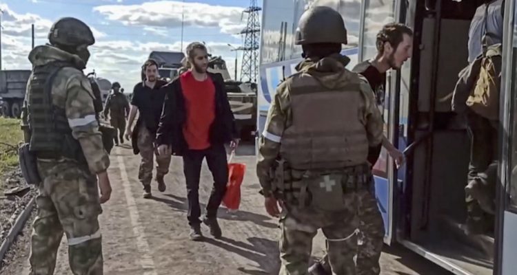 Militares rusos trasladan a combatientes rendidos en la acería de Azovstal.