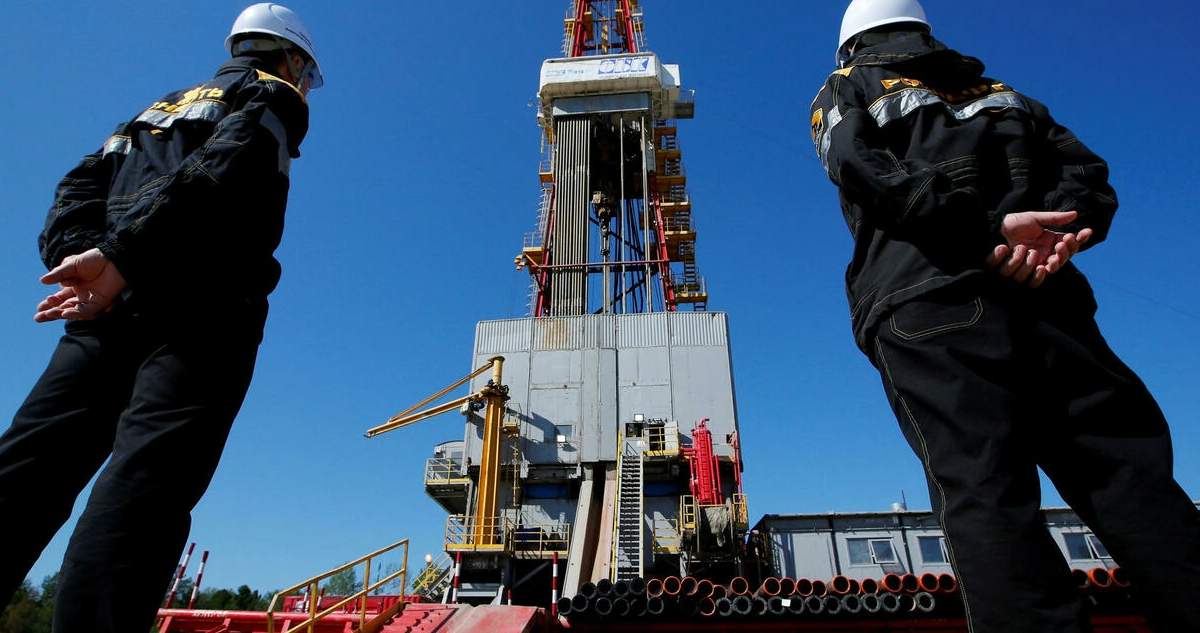 Los trabajadores observan una plataforma de perforación del campo petrolífero Prirazlomnoye, propiedad de Rosneft, en las afueras de Nefteyugansk, Rusia.