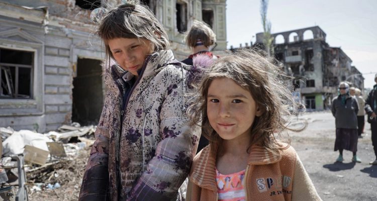 Niñas recorren las ruinas en el centro de Mariupol, Ucrania.