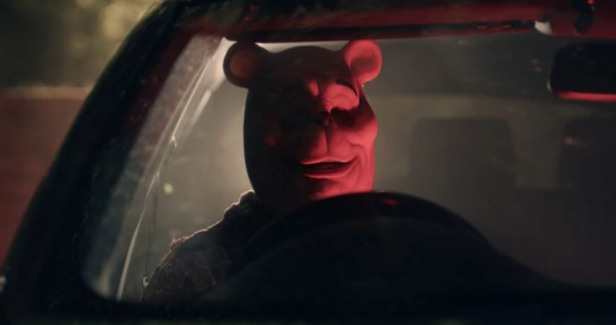 Winnie The Pooh en su película de terror. El oso aparece al interior de un auto, sujetando un volante.