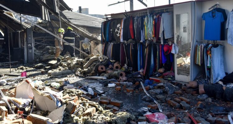 Bomberos trabajan en las ruinas del centro comercial bombardeado.