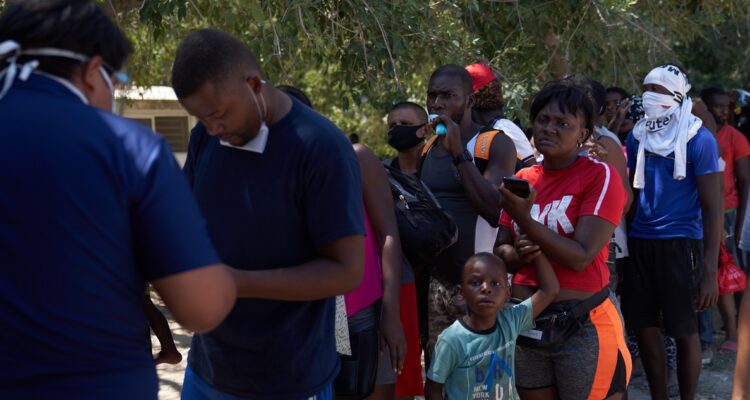 Migrantes haciendo fila para entrar a los EEUU.
