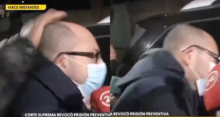 Nicolás López abre la puerta de su auto, momento en el que lo agreden. En las imágenes se ve una mano golpeándo al director y cómo este se hace hacia adelante por el impacto.