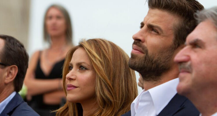 Shakira está sentada al lado de Gerard Piqué mientras miran hacia arriba.