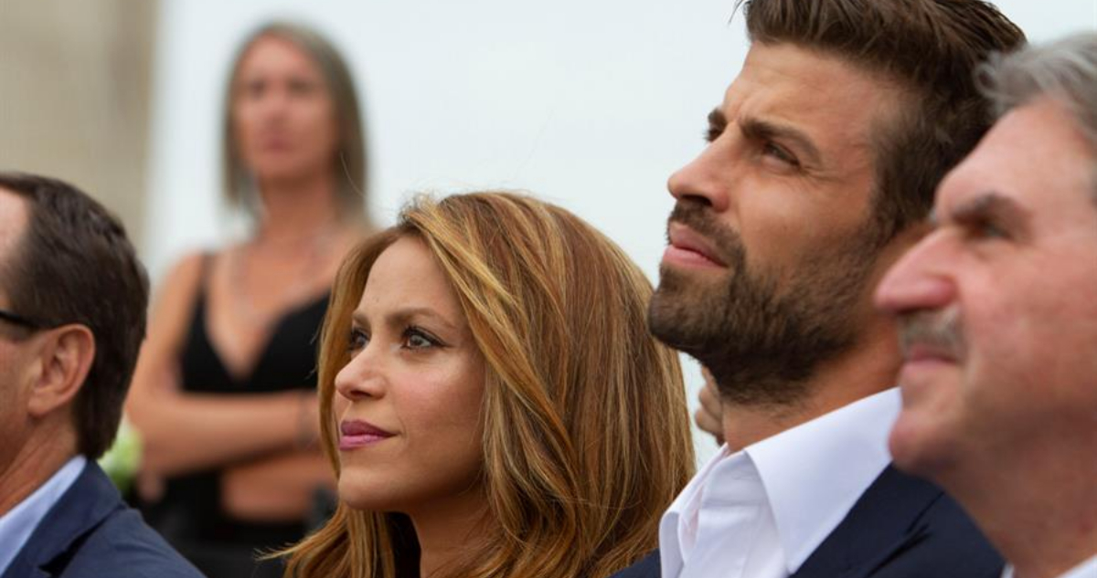 Shakira está sentada al lado de Gerard Piqué mientras miran hacia arriba.