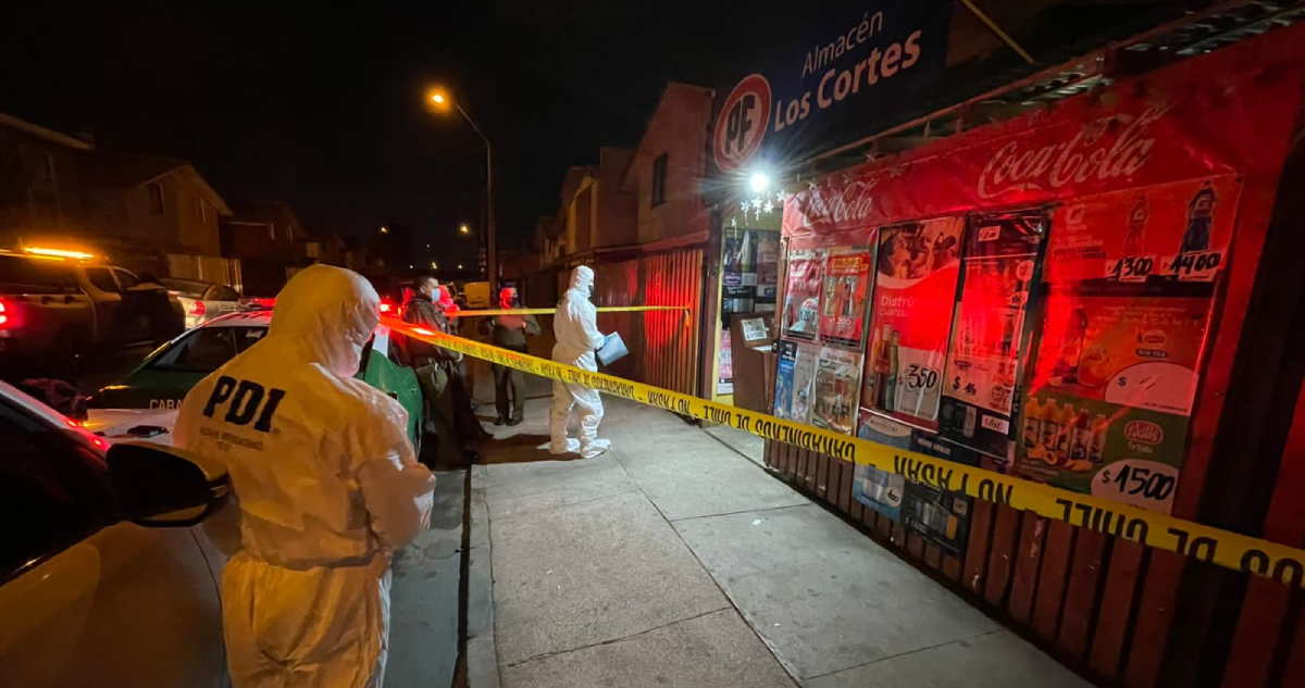 Detectives de PDI realizando las primeras diligencias en almacén donde ocurrió el crimen.