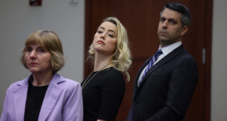 Amber Heard, en el juicio contra Johnny Depp. Observa de lado en compañía de sus abogados.