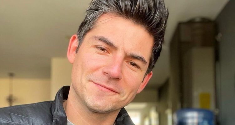 El actor Claudio Castellón sonriendo a la cámara.