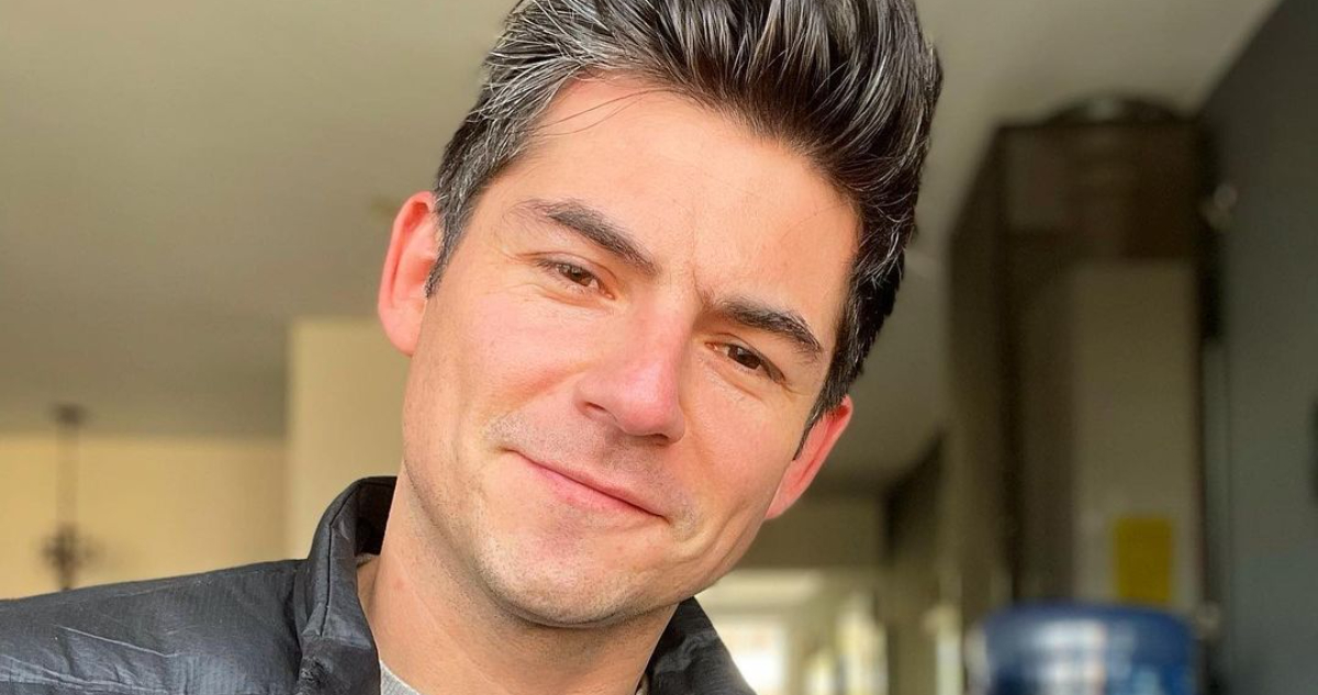 El actor Claudio Castellón sonriendo a la cámara.