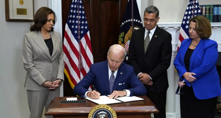 Joe Biden firmando la orden ejecutiva.