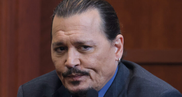 El actor Johnny Depp mira con disgusto a su derecha mientras se encuentra en el estrado en su juicio contra Amber Heard.