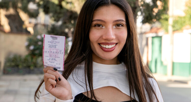Mujer con boleto para participar por pozo de lotería de Estados Unidos