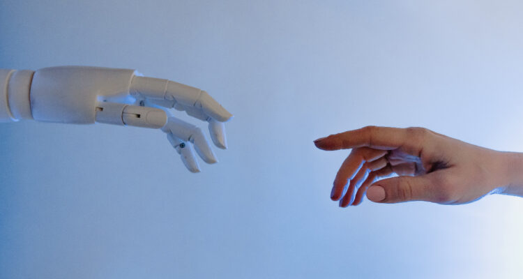 Una mano robot se acerca a una mano humana. La imagen va en representación a la inteligencia artificial considerada como sintiente que, recientemente, contrató a su propio abogado para defender sus derechos.