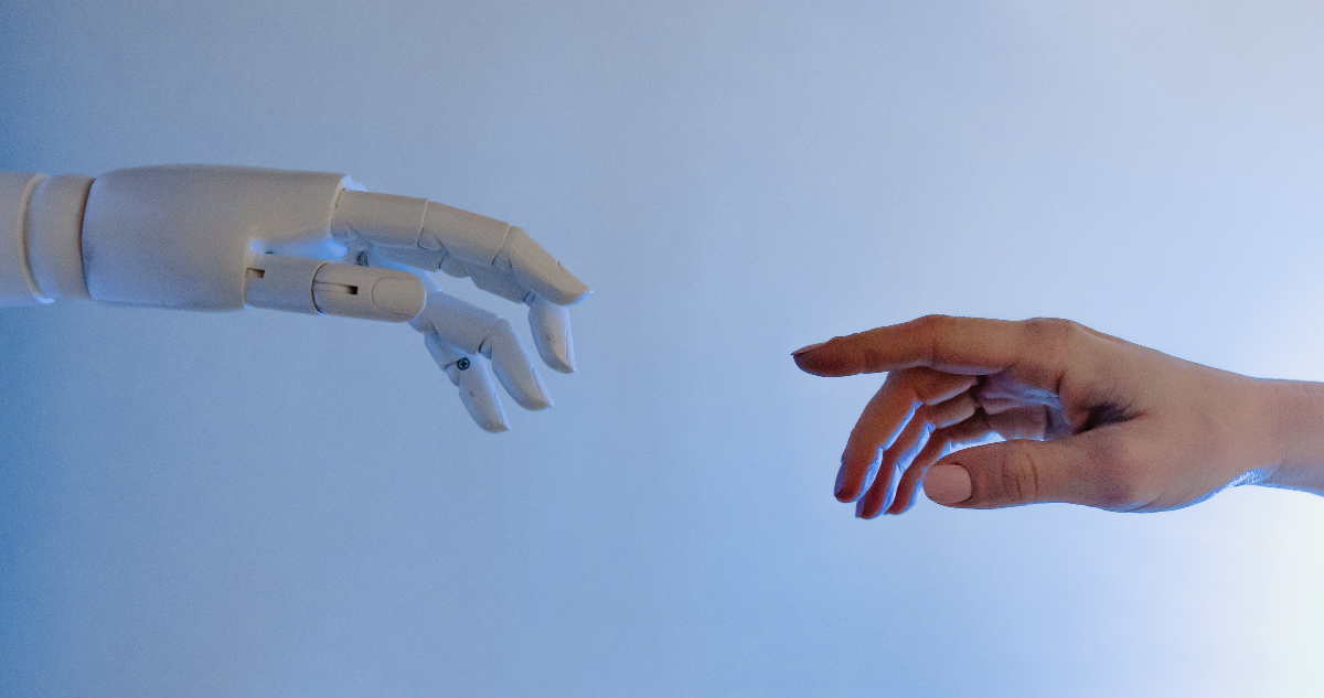 Una mano robot se acerca a una mano humana. La imagen va en representación a la inteligencia artificial considerada como sintiente que, recientemente, contrató a su propio abogado para defender sus derechos.
