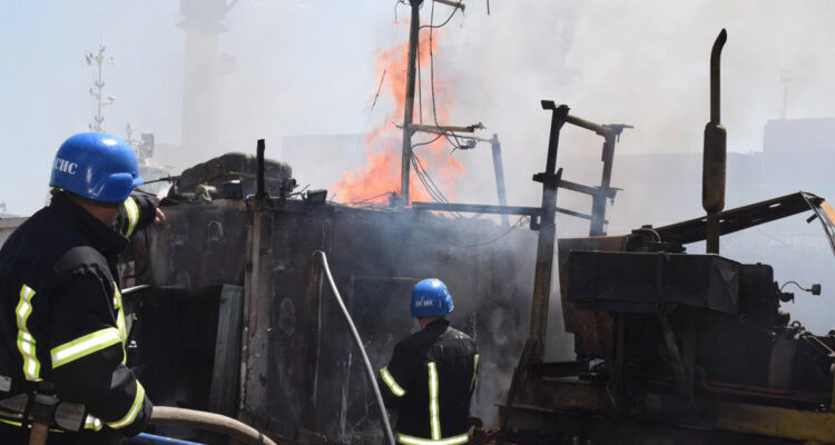 Bomberos trabajando en el puerto bombardeado.