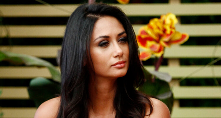 La animadora mira seria a su compañía en un programa de televisión.