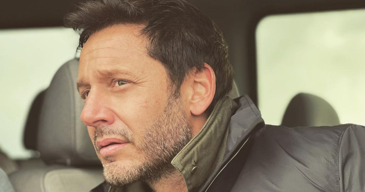 El actor Benjamín Vicuña mira hacia su izquierda con semblante serio.