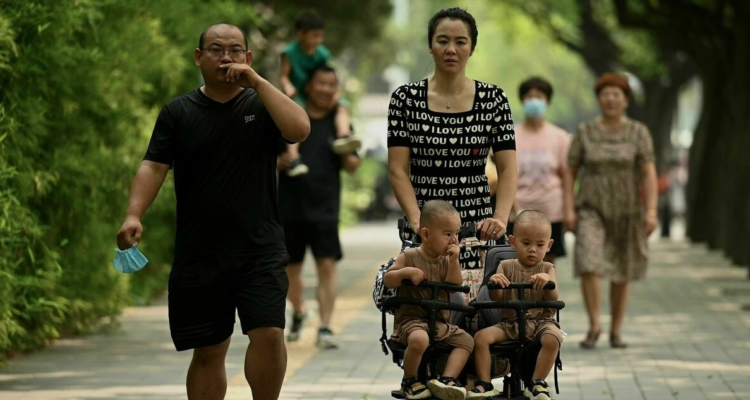 Una pareja china con dos hijos pasea en una calle de Pekín.