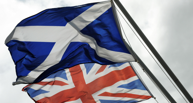 Una bandera escocesa junto a la británica.