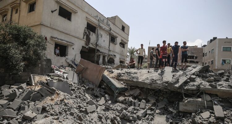 Palestinos sobre los escombros dejados por los ataques israelíes.