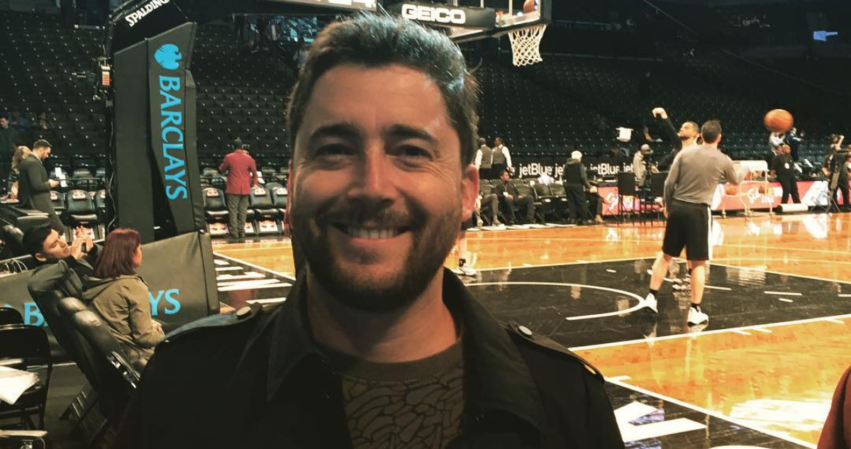 Pablo Díaz sonríe a la cámara en medio de un partido de basketball.