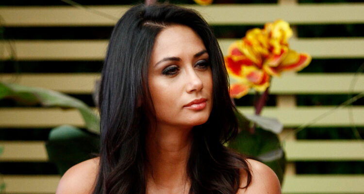 Pamela Díaz mira seria hacia un costado.