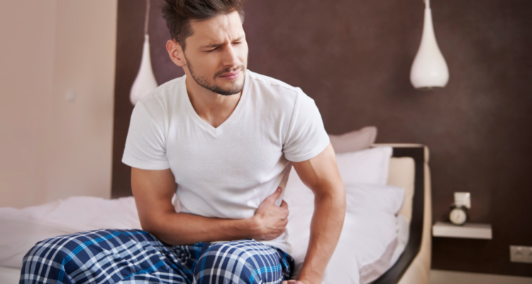 Hombre tomándose el costado debido al dolor de estomago, síntoma de la enfermedad. Brotes de cólera en el sudeste asiático