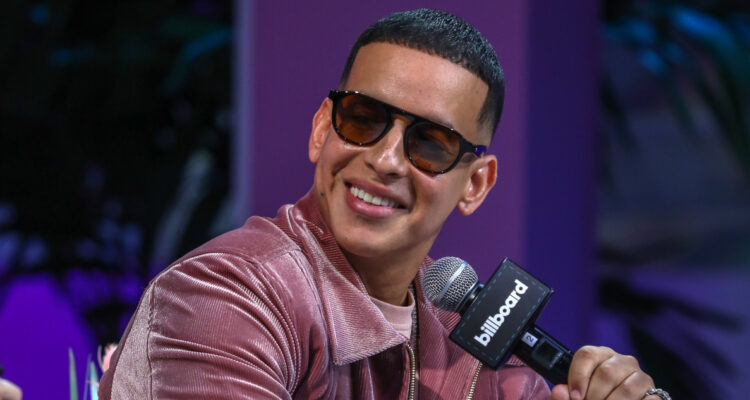 El cantante Daddy Yankee sonríe mirando hacia un costado.