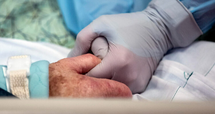 PERSONAL DE SALUD SOSTENIENDO MANO DE PACIENTE