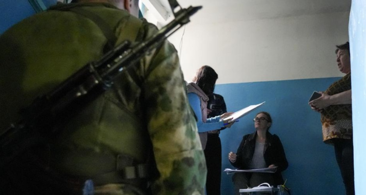 Un militar observa una votación durante el referéndum en Ucrania.