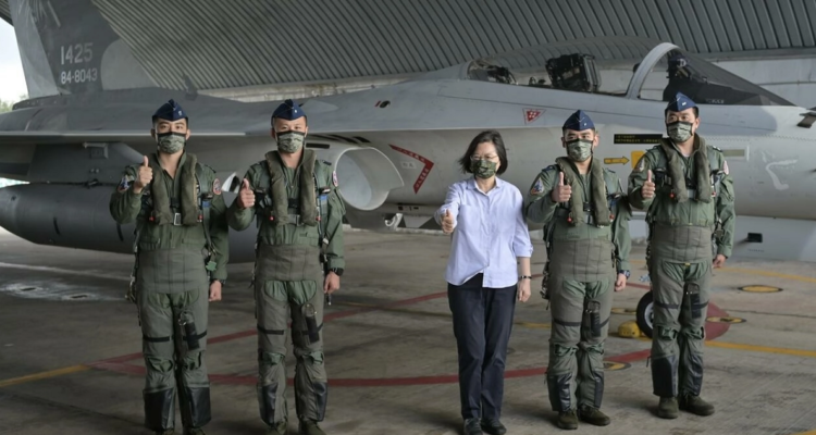 La presidenta taiwanesa, Tsai Ing-wen, posa con cuatro pilotos de la fuerza aérea ante un avión de combate.