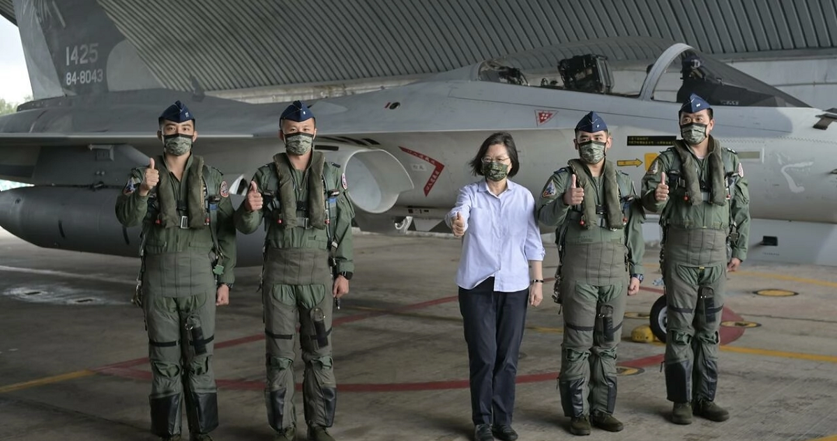 La presidenta taiwanesa, Tsai Ing-wen, posa con cuatro pilotos de la fuerza aérea ante un avión de combate.