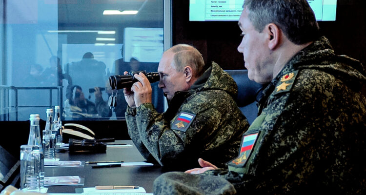 Vladimir Putin observando con binoculares los ejercicios militares.