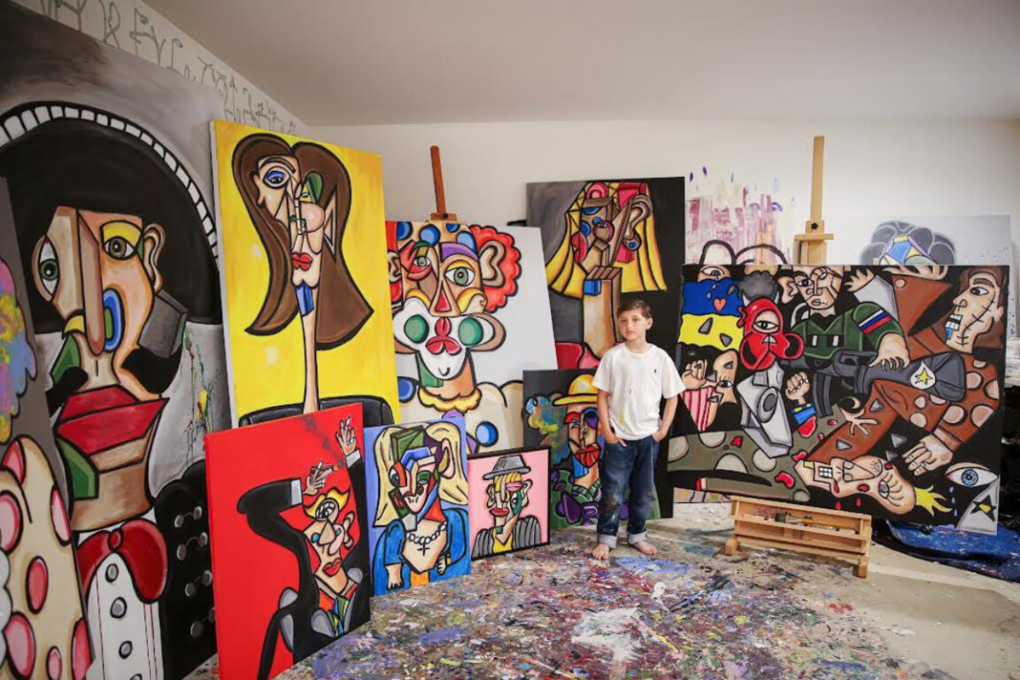 Andrés Valencia, de 11 años, posa junto a sus obras