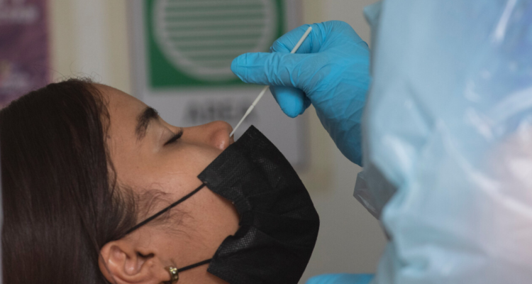 Enfermera extrayendo muestra de mucosa nasal para realizar examen PCR para detección del Covid