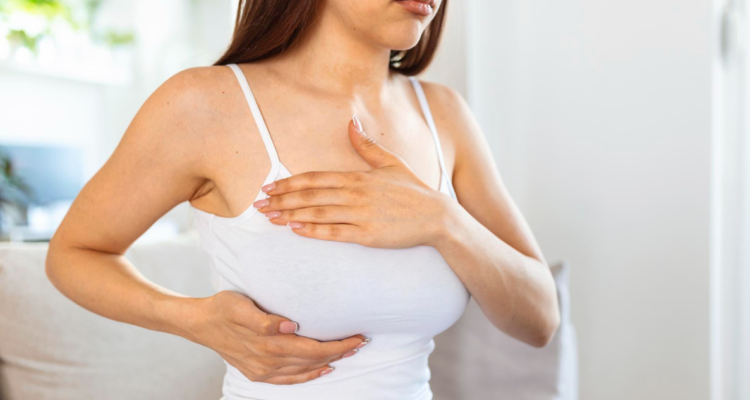 Mujer realizandose el autoexamen de detección de cáncer de mama