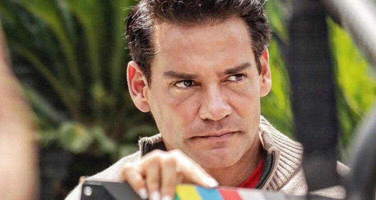 El actor Cristián de la Fuente en un set de grabación mira serio hacia un costado.