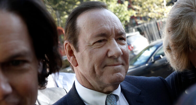 Kevin Spacey sonriendo en la entrada de los tribunales de Nueva York.