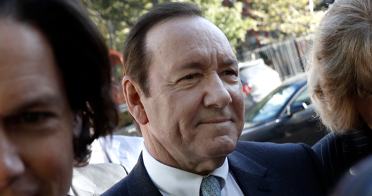 Kevin Spacey sonriendo en la entrada de los tribunales de Nueva York.