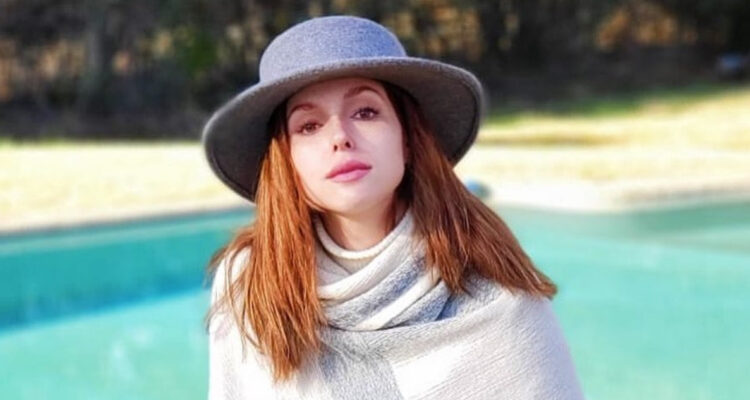 Nicole Block posa seria usando un sombrero.