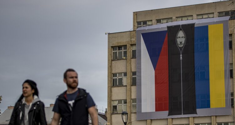 La imagen colgada en el edificio, junto a una bandera checa y otra ucraniana.