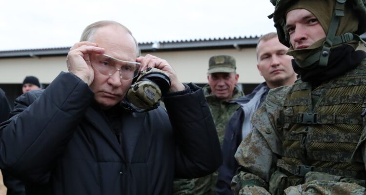 Vladimir Putin poniéndose las gafas para disparar el fusil francotirador.
