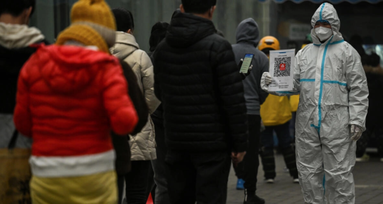 Varias personas hacen fila en Pekín para someterse a test PCR de detección del covid-19.