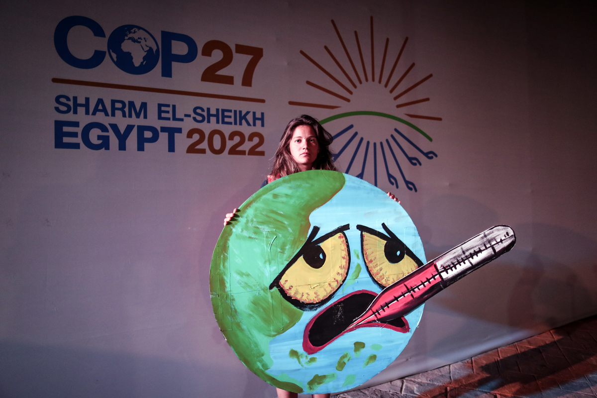 Un activista sostiene un cartel en la Conferencia de las Naciones Unidas sobre el Cambio Climático (COP27) de 2022, en Sharm El-Sheikh, Egipto, el 19 de noviembre de 2022.